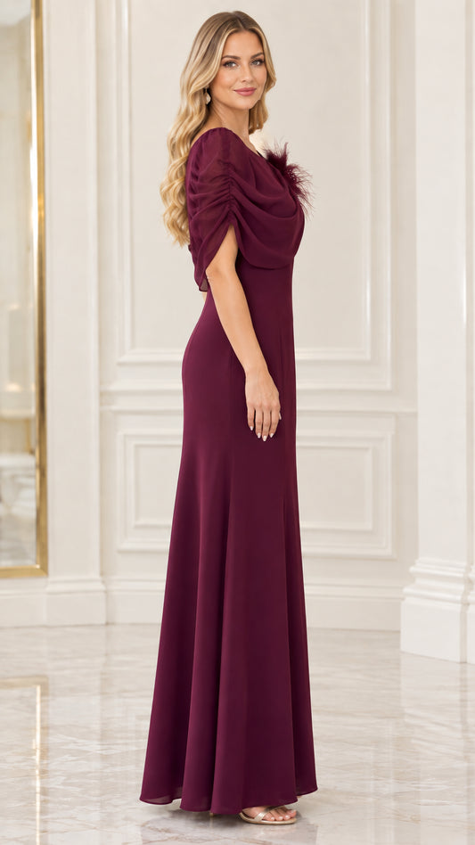 Side profile view of burgundy floor-length evening gown showing capelet sleeve and silhouette